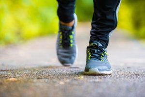 Closeup on shoe of athlete runner man feet running on road